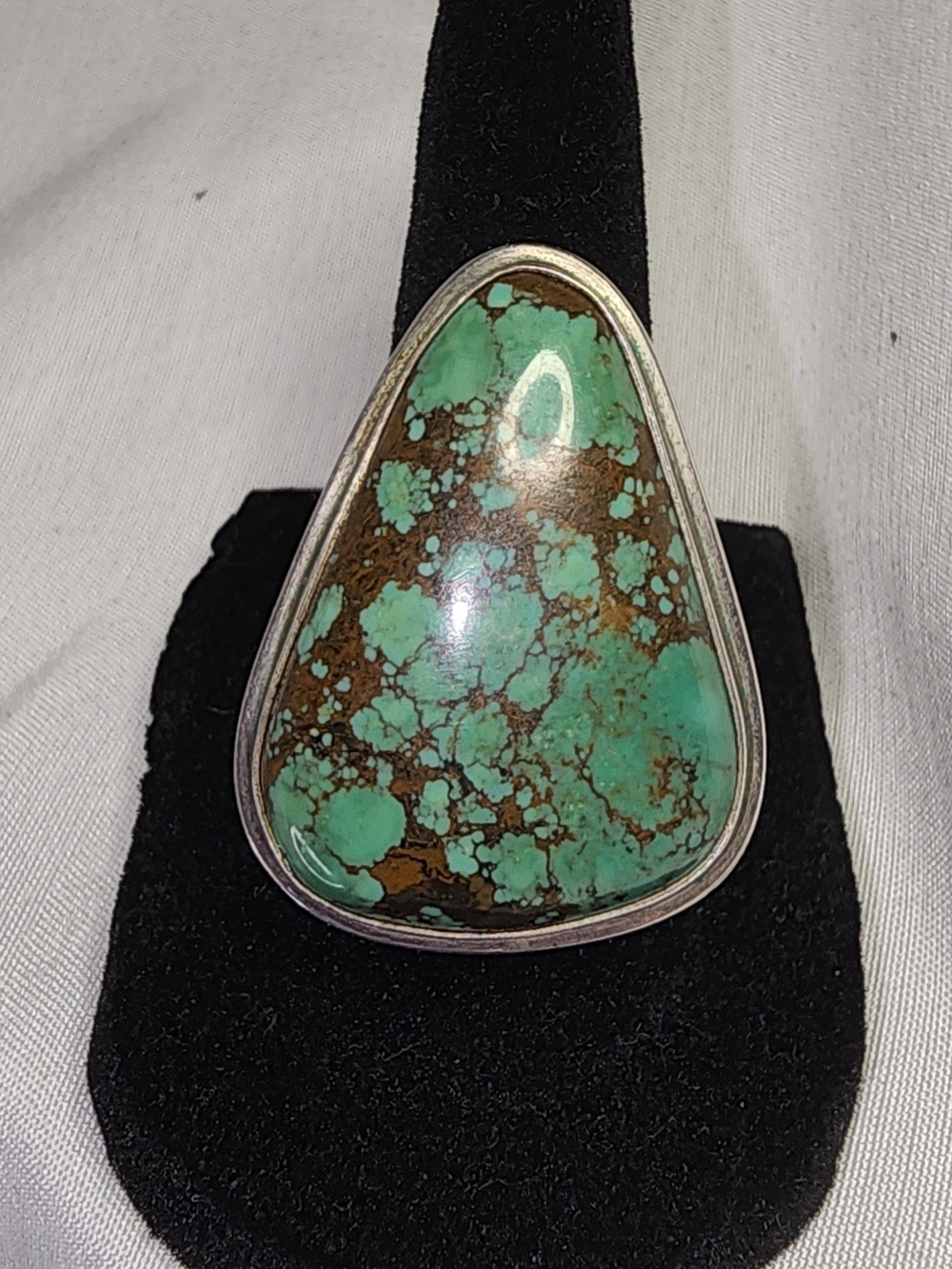 Large, triangular ring features a green turquoise stone SZ 7
